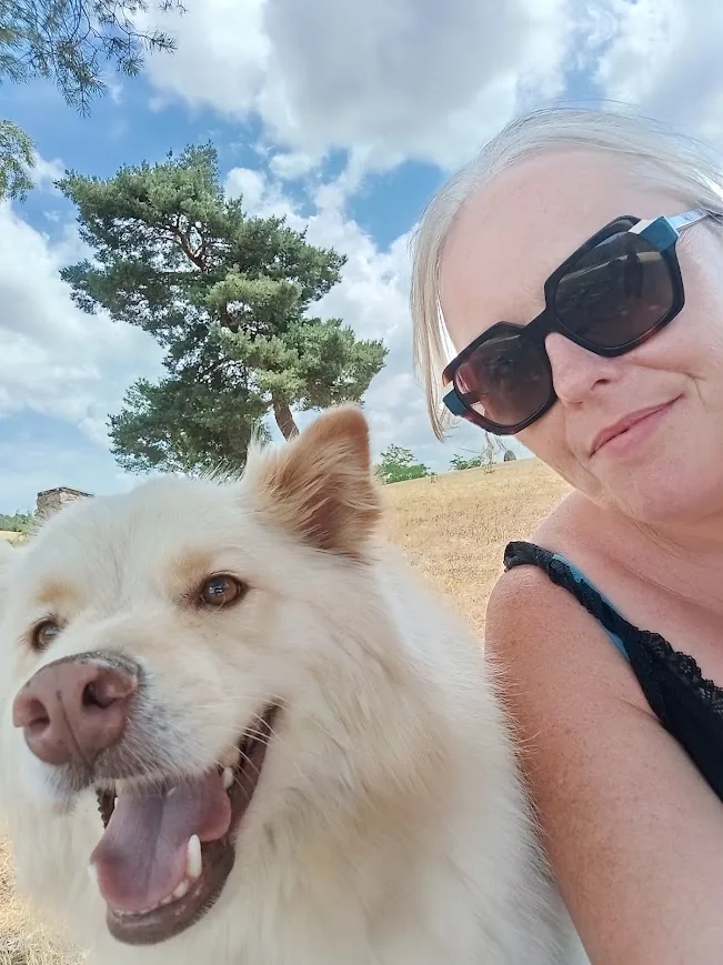 Selfie en extérieur d'une femme et de Tips adulte, museau souriant, sous un ciel bleu avec un pin en arrière-plan